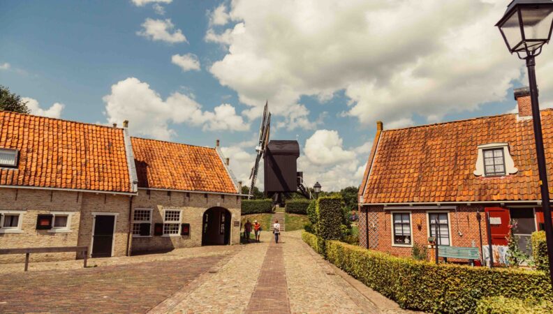 Mühle und Häuser mit orangefarbenen Dächern in Bourtange